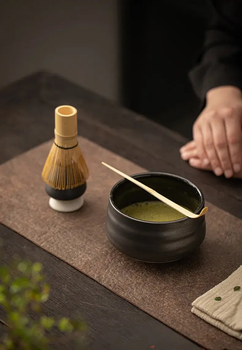 black matt bowl, bamboo whisk and bamboo tea scoop of 4 piece ceramic matcha tea set with whisk holder
